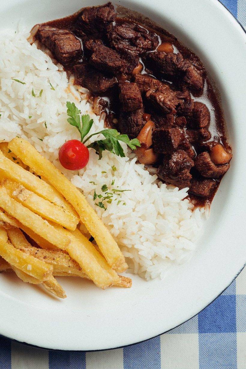 Picadinho com arroz e batata frita no prato branco