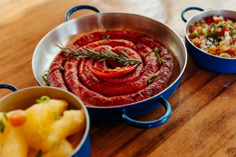 Linguica artesanal em espiral na panela azul