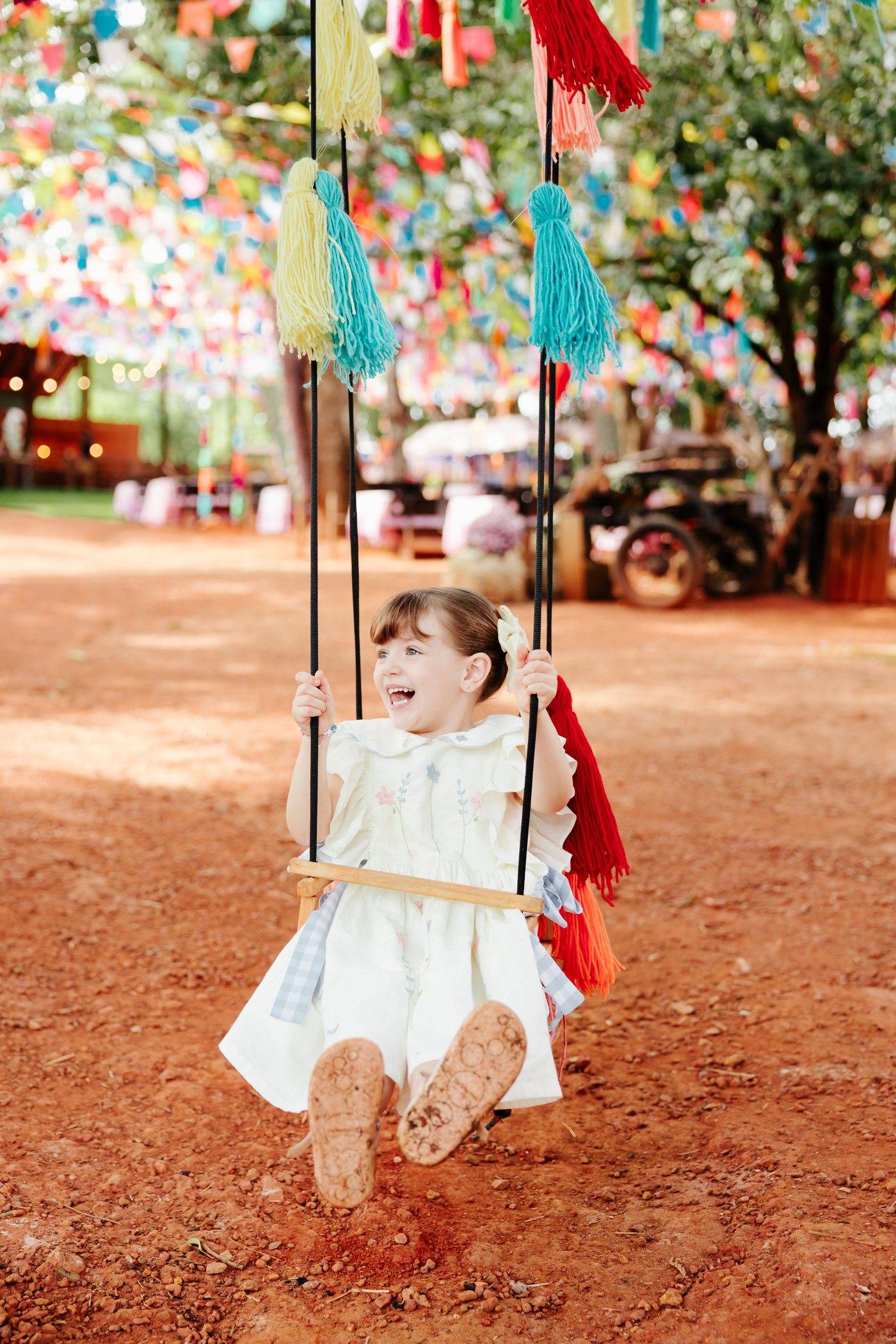 Menina no balanço sob as bandeirinhas de festa