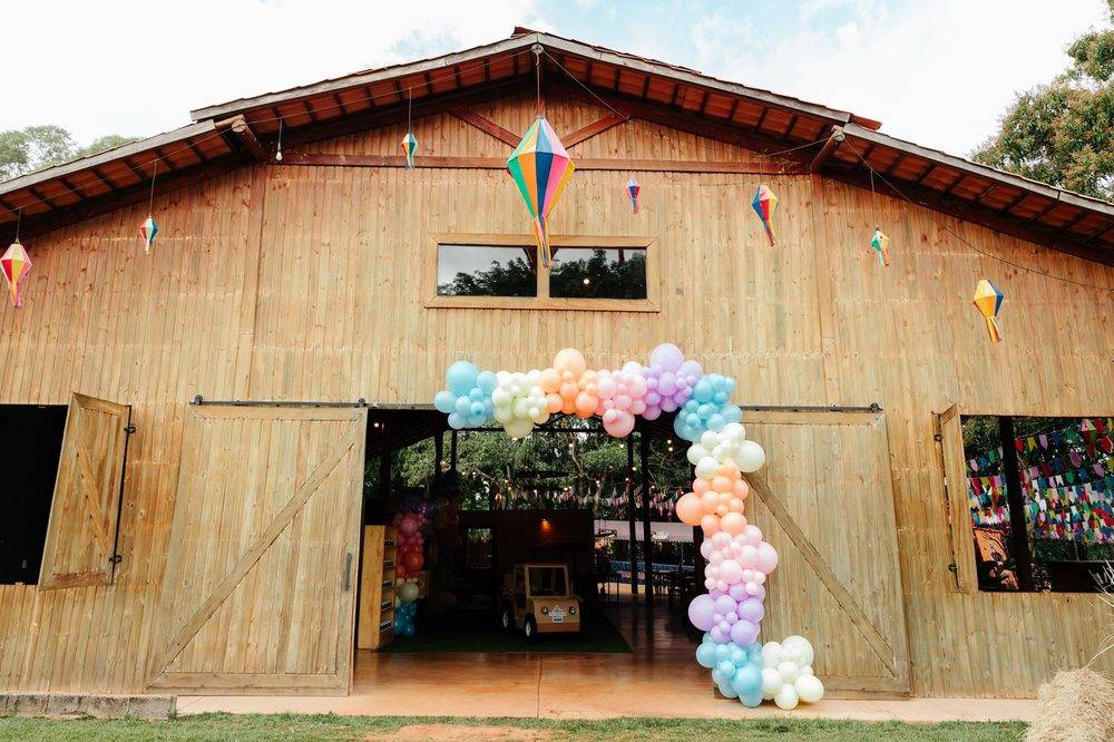 Fachada do celeiro com arco de balões em tons pastel