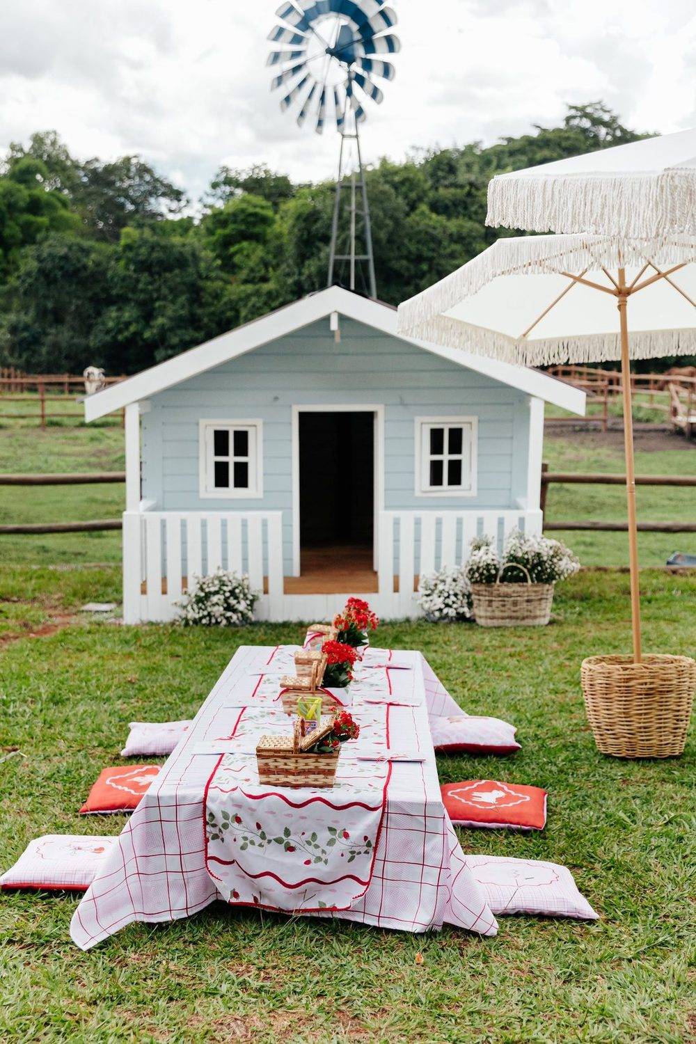 Casinha de boneca com piquenique no gramado