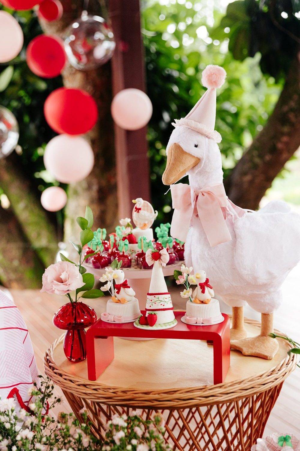 Mesa de docinhos com o ganso de pelúcia de chapéu