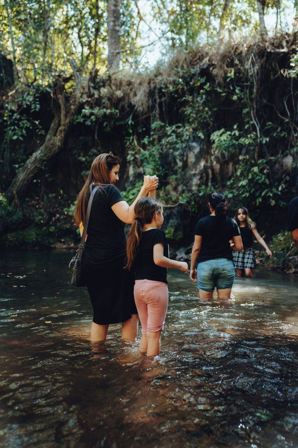 Familia caminhando dentro do corrego